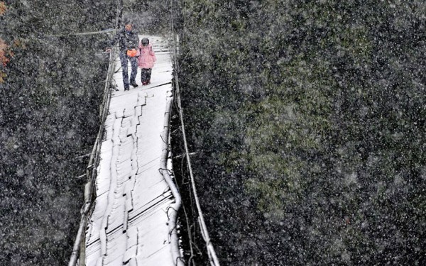 Cruzando un puente roto en la nieve para ir a la escuela en Dujiangyan, Provincia de Sichuan, China