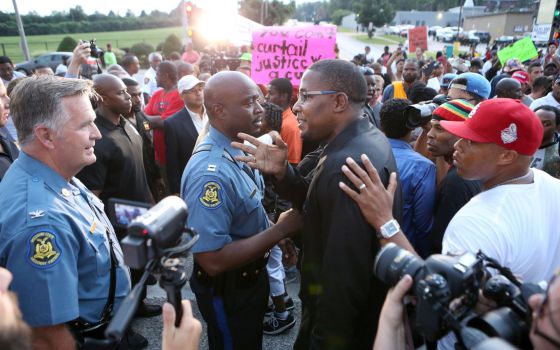 El jefe del dispositivo policial junto a un activista negro. / David Carson (AP)