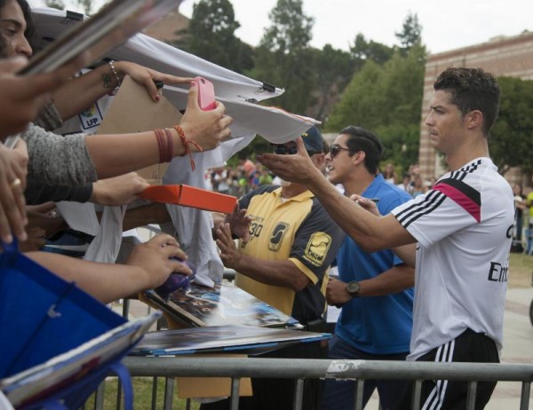 El jugador del Real Madrid Cristiano Ronaldo (d) dirma autógrafos durante un entrenamiento en el campus de la Universidad de California en Los Ángeles.